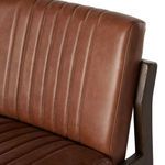 High detail close-up of vertical stitching on chestnut leather backrest