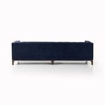 Corner detail focusing on tufted navy velvet upholstery and right angle arms