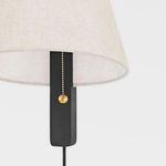 Close-up of sconce showing beige fabric shade with black vertical mount and brass pull chain ball