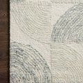 Close-up of the rug’s corner on dark wood floor showing detailed wool texture and pattern