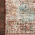 Close-up of rug corner on dark wood floor highlighting intricate border pattern and color mix