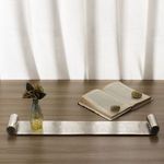 Tray styled on wooden surface with small vase and open book, illustrating scale and use