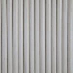 Close-up of ribbed vertical grooves on antique white drawer front with subtle distressing