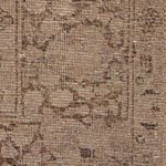 detailed close-up of vintage rug pattern with neutral beige and brown hues and woven texture