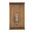 Front-facing view of sconce with bulb turned off inside brass and glass housing