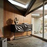 Zurich Console styled in mid-century modern room with leather chair, angular skylight, and stone floor