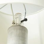 Side view of lamp with shade showing hand-painted checked base and neutral-colored fabric shade.