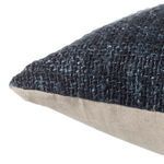 Side angle showing pillow's textured dark woven fabric front and smooth beige linen back