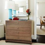 Ming Large dresser in a softly lit room with blue lamp, red boxes, flowers, and mirror on top