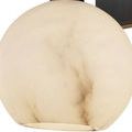 Close-up of alabaster globe with visible brown veining against smooth cream surface