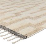 Close-up showing ribbed wool texture and cream and tan color contrast near rug fringe