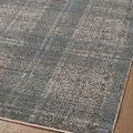 Detailed view of rug’s plaid pattern showcasing blue and charcoal tones with textured surface