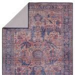 Backside of rug folded over, displaying neutral gray backing fabric