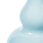 Close-up of glossy light blue ceramic finish showing smooth texture and subtle reflections