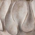 Close-up of textured spoon-like swells pressed into the rugged gray concrete base