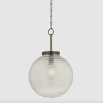 Falls Mills pendant with round Murano-inspired glass globe featuring subtle swirl texture and aged brass hardware