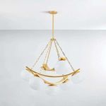 Chandelier installed in room with white ceiling showing smooth opaque white glass shades on gold chains and curved bands