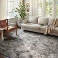 Austen Stone Pebble rug styled in living room with sofa, chair, and natural light from windows