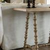Detail view of turned spindle legs and two black candlesticks on Kirkwood Console Table beside sofa