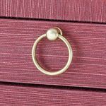 Close-up of brass ring pull handle on red textured drawer front