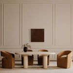 Dining area with four Barrow Rolling Dining Chairs around oval stone table under wall art