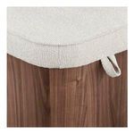 Close-up of oatmeal fabric with textured piping and loop handle detail on walnut base