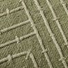 Close-up of textured cotton fabric with raised linear embroidery detail on moss green pillow