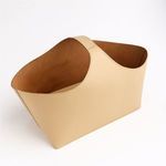 Angled view showing interior suede texture and single handle attachment on beige Napa bucket