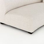 Close-up of sofa’s gently curved front seat base showing upholstery and dark feet