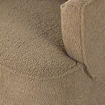Side angled detail of chair’s back and armrest corner with plush fabric