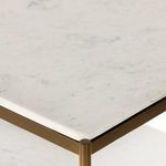 Sharp marble edge meeting antique brass vertical post with visible frame welding point