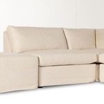 Front angle view of sectional highlighting cushioned seats and slipcover fabric