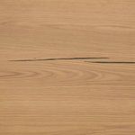 Close-up detail of smooth oak wood surface with dark resin grain line
