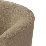 Close-up on curved armrest seam and soft camel fabric