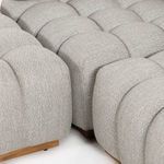 Detail of sectional joint where two seating pieces meet, highlighting tufting and teak base