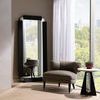 Tobin table next to modern gray armchair, black framed mirror, and large window with sheer curtain