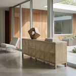 Washed walnut sideboard styled in modern room with glass walls, sculpture, and minimalistic chair
