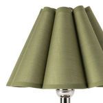 Close-up detail of green fabric pleated lamp shade showing weave texture and scalloped edges