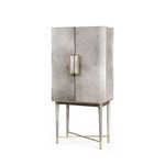 Tall bar cabinet draped in plush gray hair-on-hide with polished brass accents on legs and handles