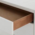Open top drawer showing interior wood finish contrasting with sand white exterior