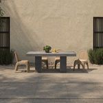Wide angle of four Kendall chairs around rectangular stone dining table by beige wall