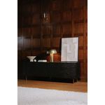 Nanu Table Lamp on black textured cabinet against wood panel wall featuring modern decor and artwork