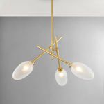 Chandelier illuminated softly, angled showing three frosted oval shades and aged brass metalwork
