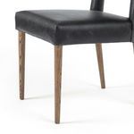 Close-up of chair backrest corner showing leather seams and posterior gap in design
