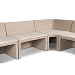 View focusing on joined seat cushions and curved corner of rattan banquette