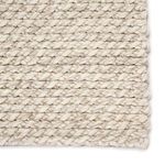 Detailed close-up of chunky gray and white braided wool texture with visible stitching