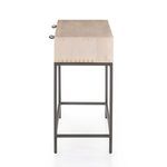 Side view of narrow metal legs and frame under light wood top with visible grain