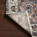 Samra rug corner flipped to show the backside weave and cream fringe on dark wood floor