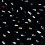 close crop on clustered boats showing details of boat shapes and colors on dark water