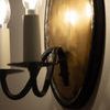 Close-up side angle highlighting hand-forged iron arm details and hammered brass backplate texture